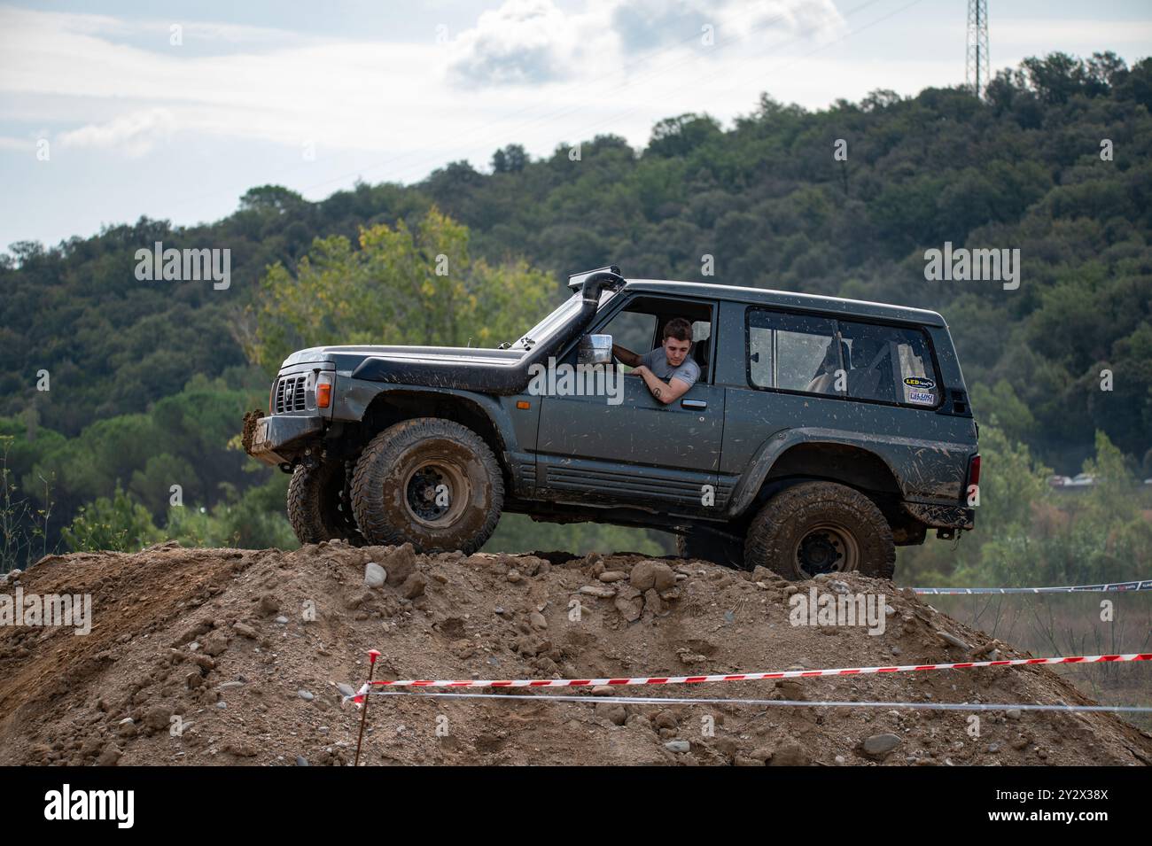 Vue latérale d'un véhicule hors route Nissan Patrol GR Y60 classique vert-gris japonais de quatrième génération au sommet d'un obstacle à la campagne Banque D'Images