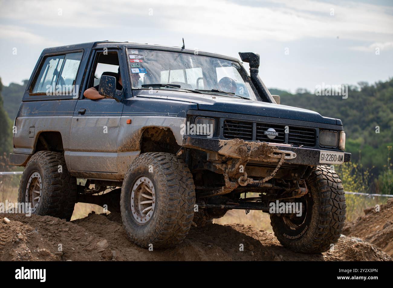 Véhicule tout-terrain Nissan Patrol série 260 de troisième génération modifié pour la conduite hors route extrême en surmontant un obstacle boueux dans la campagne Banque D'Images