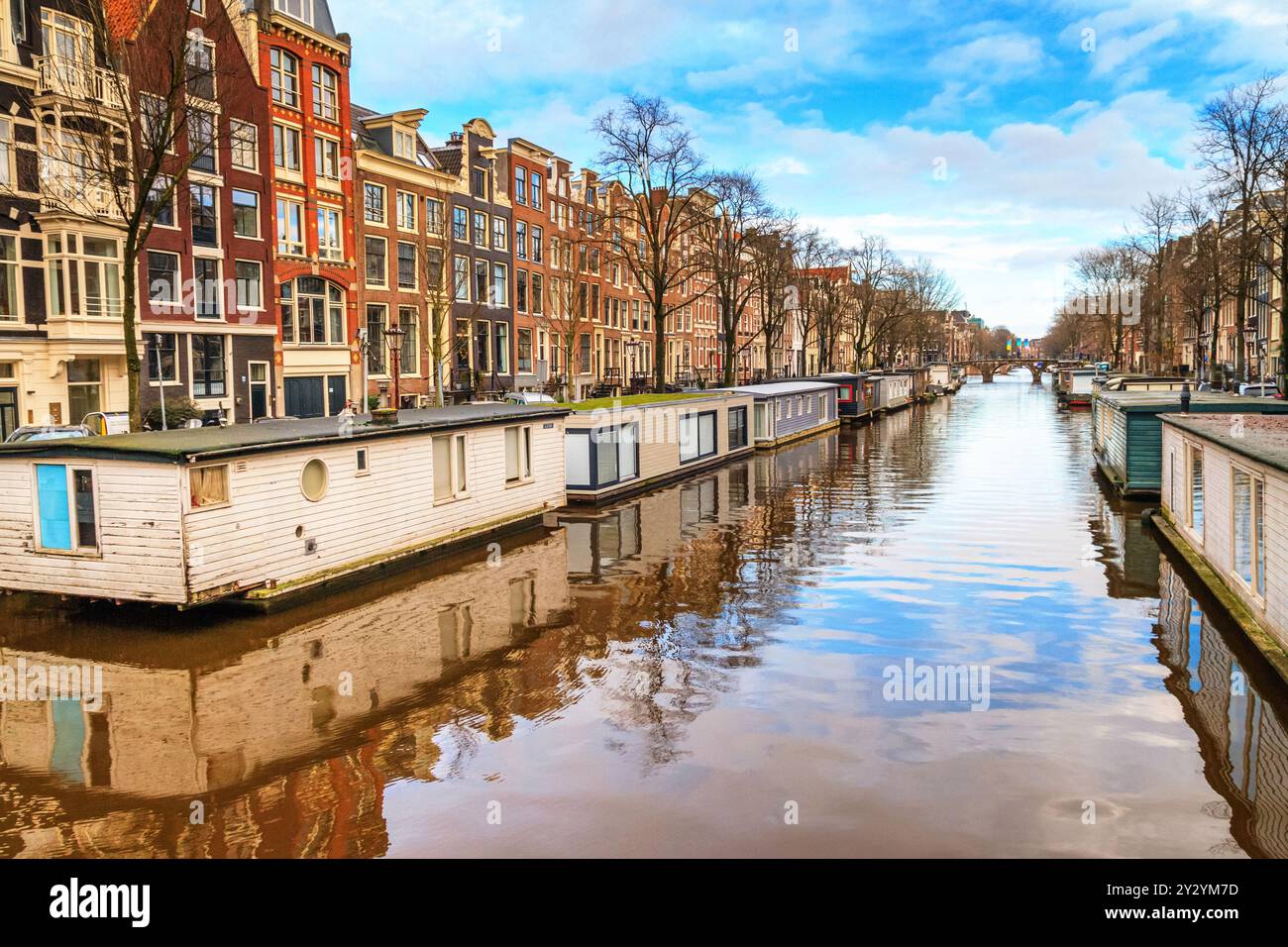 Paysage urbain par une journée ensoleillée d'hiver - vue sur le canal d'eau avec péniches dans le centre historique d'Amsterdam, pays-Bas Banque D'Images