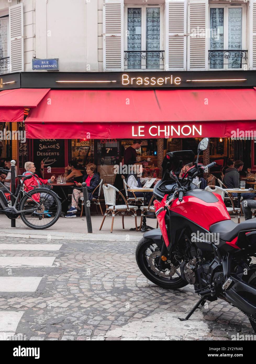Paris - 4 septembre 2024 - photo de rue de la rue française de Montmartre avec Café et Brasserie et Red Motorbike Banque D'Images