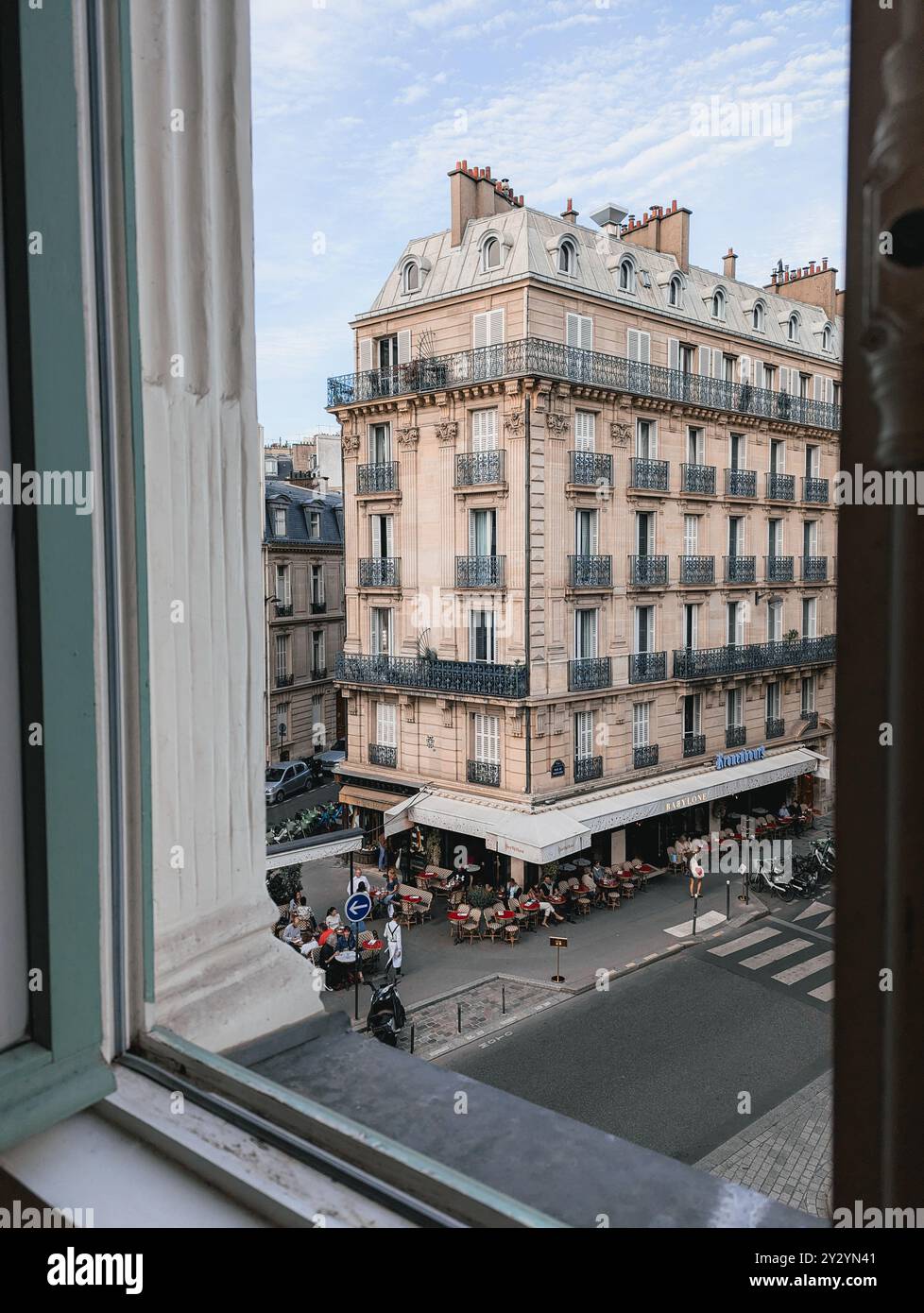 Paris - 4 septembre 2024 - ouverture de la fenêtre de l'hôtel donnant sur la magnifique rue française et le café avec repas en plein air Banque D'Images
