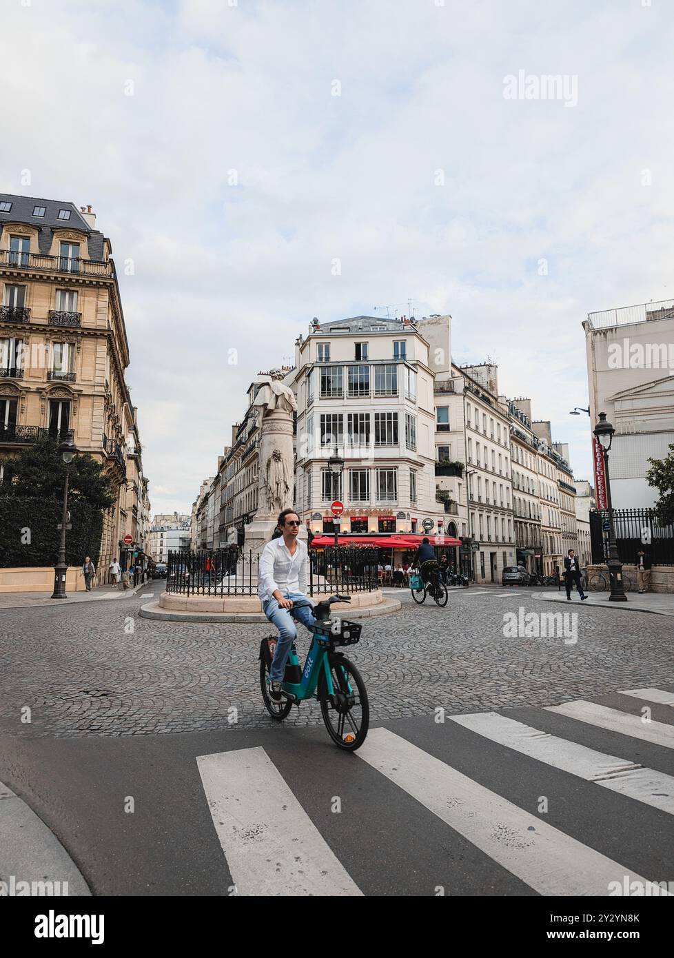 Paris - 04 septembre 2024 - pittoresque rue française avec café et cycliste dans le 9ème arrondissement Banque D'Images