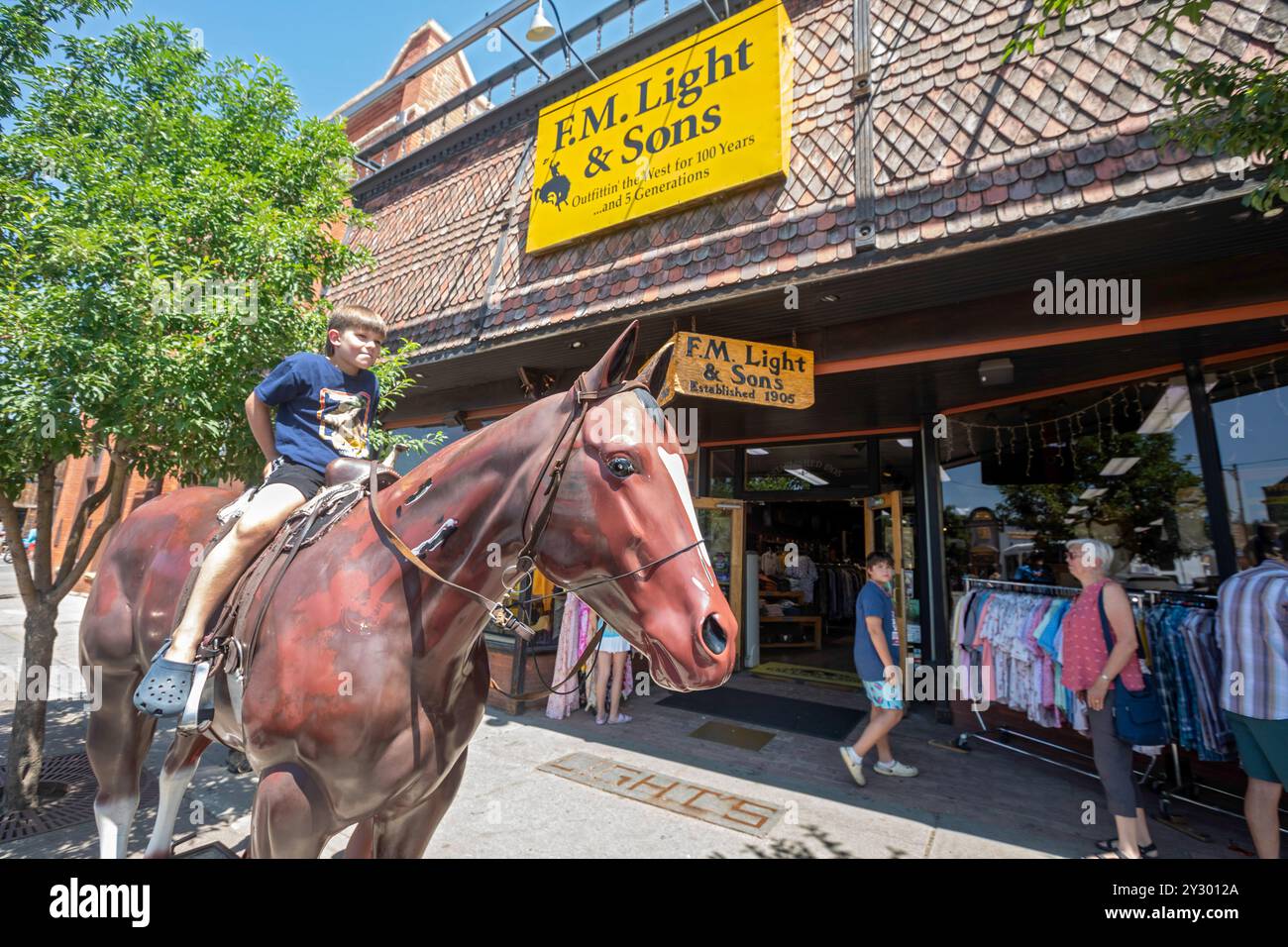 Steamboat Springs, Colorado - Un garçon est assis sur un cheval en fibre de verre à l'extérieur de F.M. Light & sons, un magasin de vêtements occidentaux très médiatisé. Banque D'Images