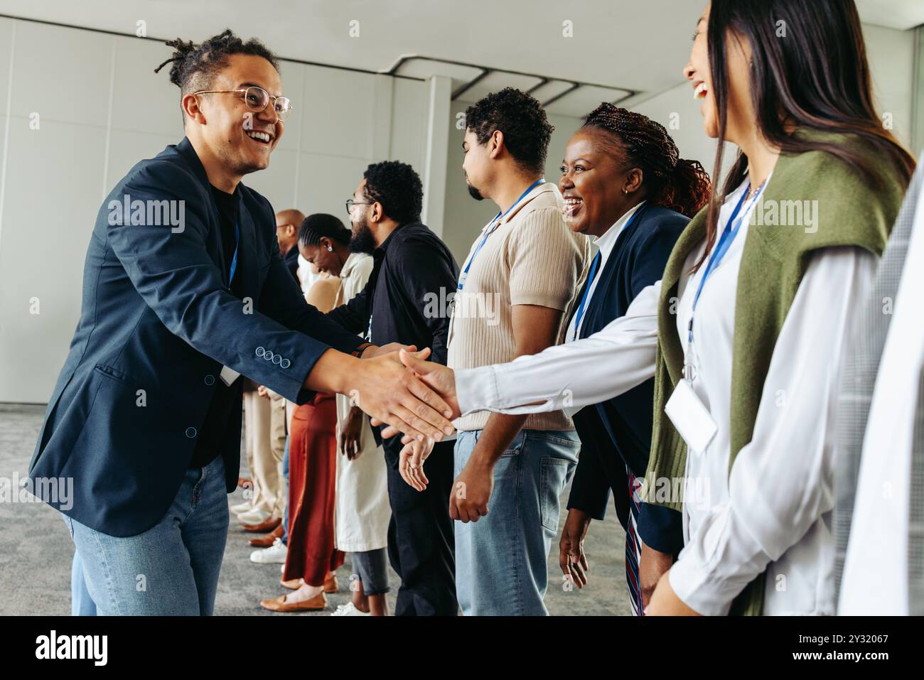 Groupe de professionnels d'affaires serrant la main et réseautant dans un environnement de bureau, créant des connexions et établissant des relations. Banque D'Images