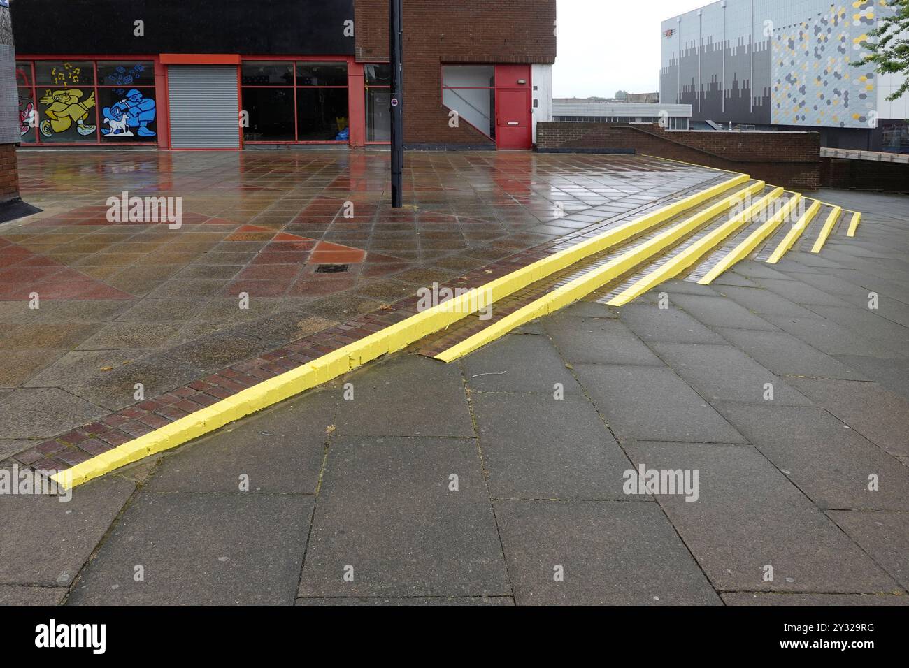 Un trottoir plat à l'extérieur du parking est adjacent à une passerelle en bas de la colline vers la zone commerçante de Basildon points de passage potentiels pour les piétons peints en jaune Angleterre Royaume-Uni Banque D'Images