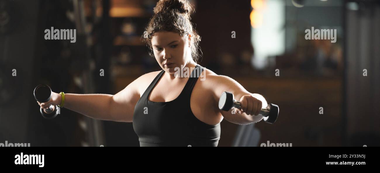 Une jeune femme motivée montre de la force et de la confiance tout en s'entraînant en vêtements actifs. Banque D'Images