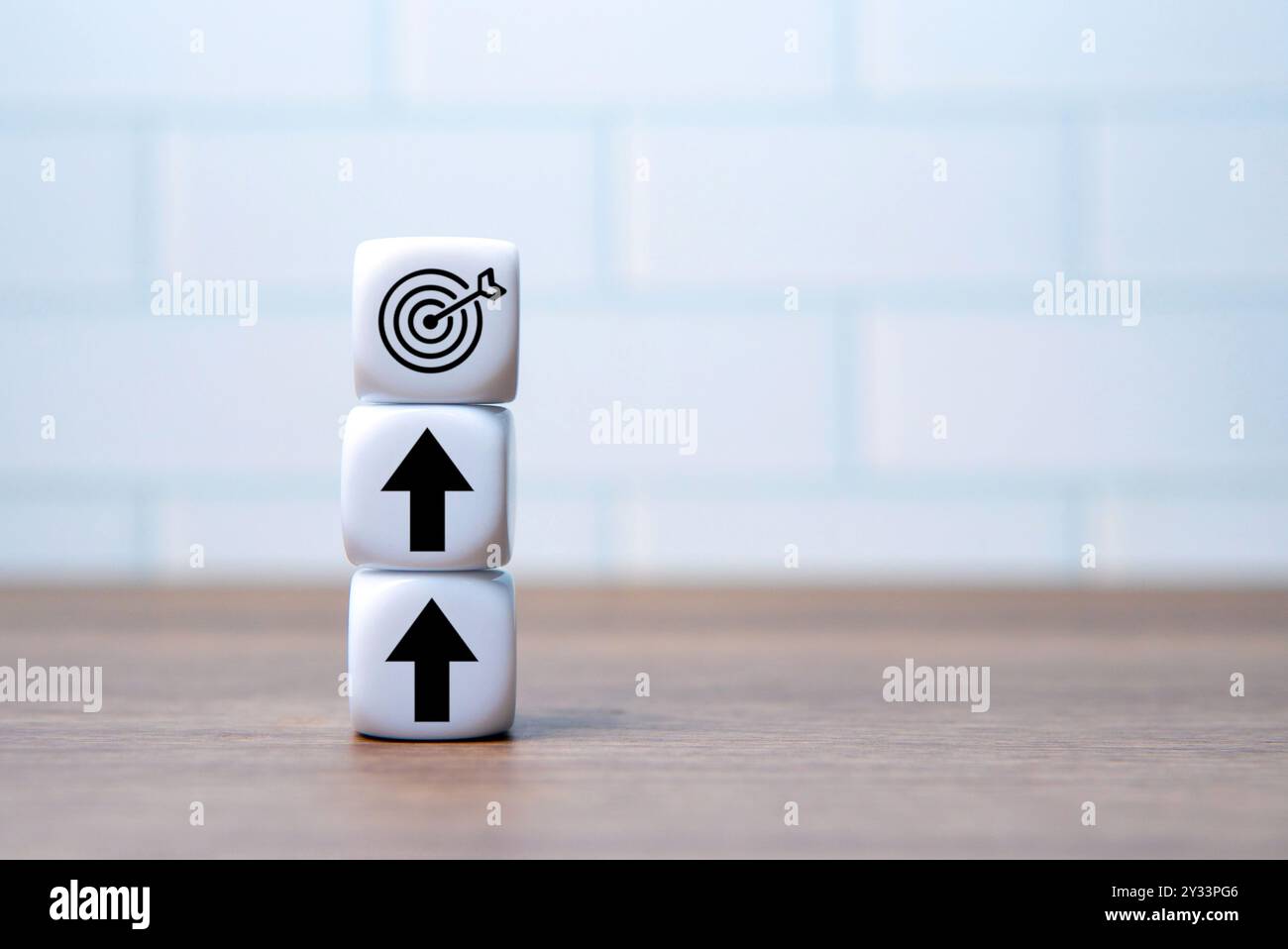 Dés blancs empilés les uns sur les autres avec le symbole de cible et la flèche vers le haut. Copier l'espace pour le texte. Objectifs, progrès, succès, orientation et croissance Banque D'Images