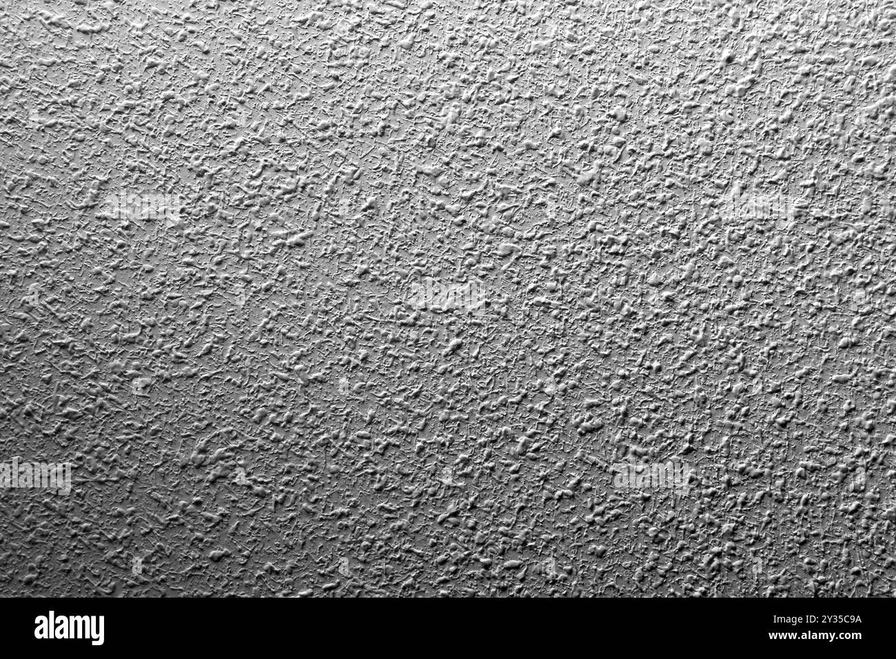 Surface de mur pointillé peint en ciment blanc ombré comme fond abstrait rugueux Banque D'Images