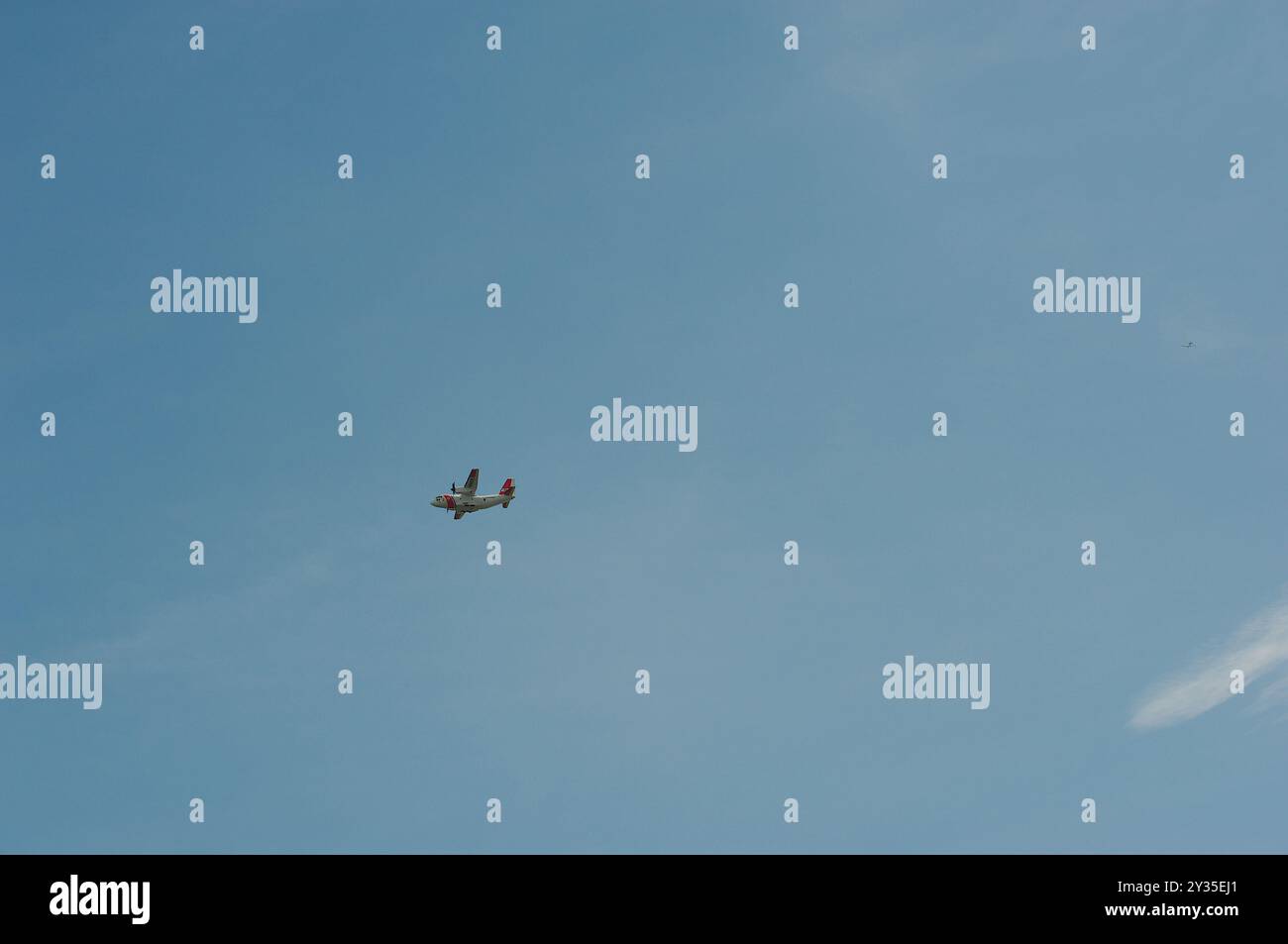 Vue jusqu'à un fond de ciel bleu à un avion militaire blanc allant de droite à gauche. Soleil de Floride dans le soleil de début d'après-midi avec un ciel bleu vif. R Banque D'Images