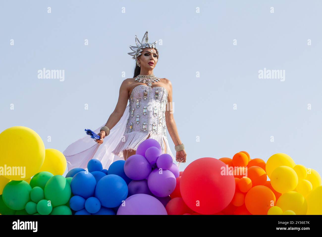 Goiânia GOIAS BRÉSIL - 08 SEPTEMBRE 2024 : une personne LGBT, vêtue de blanc avec un char décoré de ballons, danse, à la LGBT Pride Parad 2024 Banque D'Images