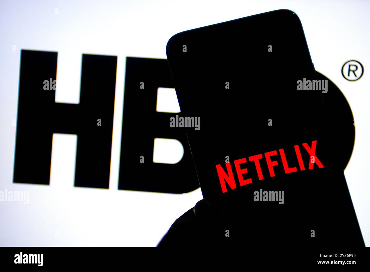 Dans cette illustration photo, un logo Netflix vu affiché sur un smartphone avec un logo HBO en arrière-plan. Banque D'Images