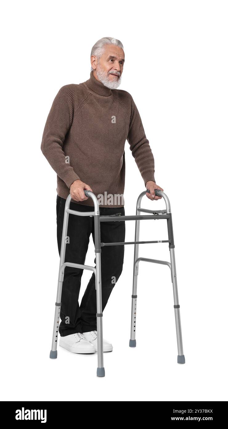 Homme senior utilisant le cadre de marche sur fond blanc Banque D'Images