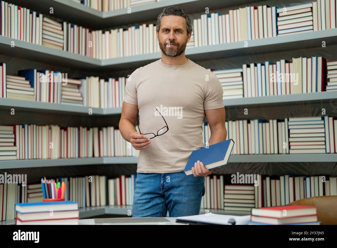 Journée des enseignants. Professeur tuteur en classe scolaire. Connaissances, éducation. Homme avec livre enseignement leçon en classe. Examen universitaire. Étudier enseigner à l'université Banque D'Images
