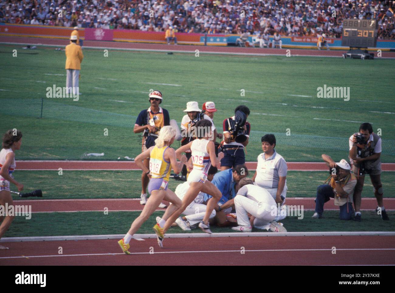 20 août 1984 ; Los Angeles, CA, États-Unis ; lors de la finale olympique de 1984, lors du 3 000 mètres, MARY DECKER s'est mêlée à Zola Budd, une originaire d'Afrique du Sud qui courait pour la Grande-Bretagne. Decker trébucha, tomba sur le champ et se blessa à la hanche. Image : les médecins ont tendance à PRENDRE DU RELAIS au fur et à mesure que les autres coureurs passent. Credit : Arthur Grace/ZUMAPRESS.com/Alamy Live News Banque D'Images