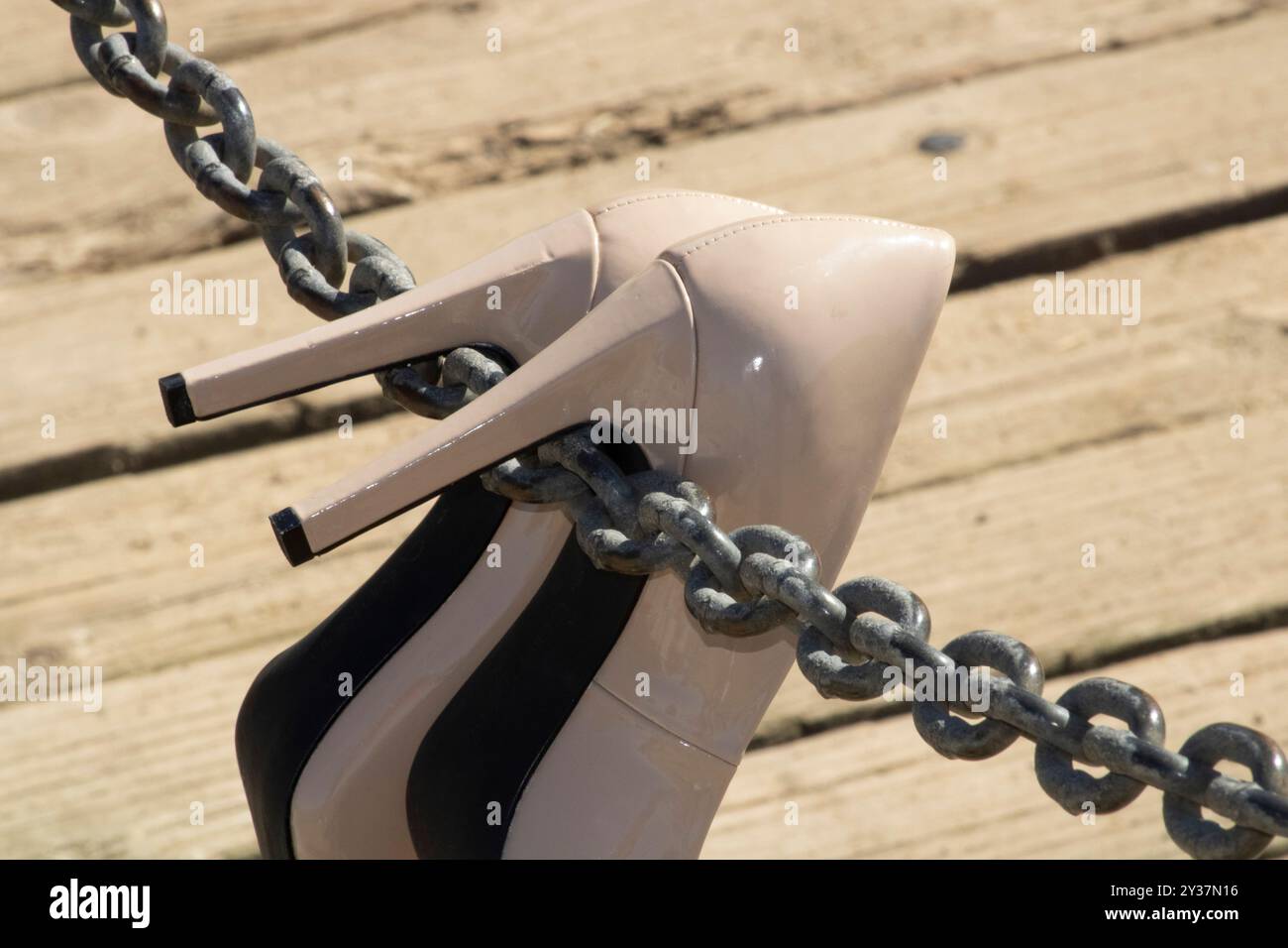 paire de talons beiges suspendus à une corde à chaîne sur un pont Banque D'Images