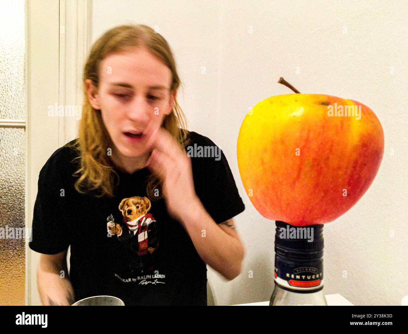 Homme et Apple jeune homme et une pomme à sa table de cuisine. Berlin, Allemagne. MRYES Berlin Koppenstasse Berlin Allemagne Copyright : xGuidoxKoppesxPhotox Banque D'Images