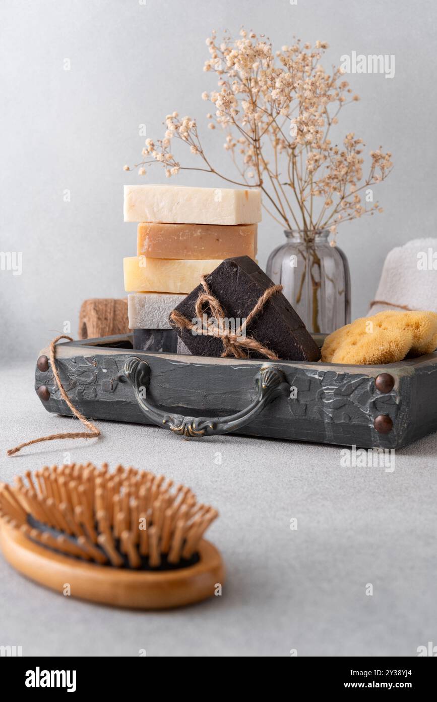 Un ensemble de salle de bain magnifiquement agencé avec des savons faits à la main, une brosse à cheveux en bois et une éponge naturelle. Idéal pour les soins naturels de la peau, les routines de bien-être, Banque D'Images