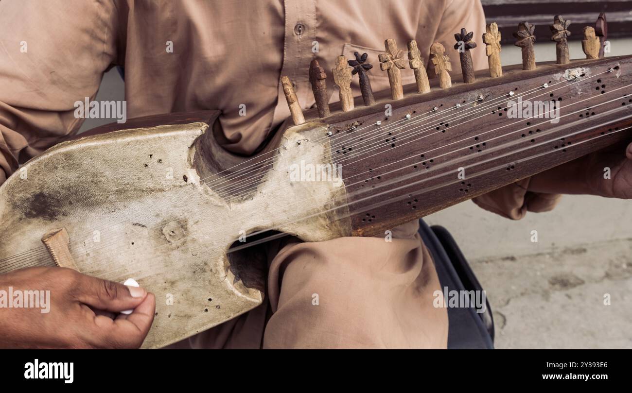 Un homme joue d'un instrument à cordes avec beaucoup de cordes Banque D'Images