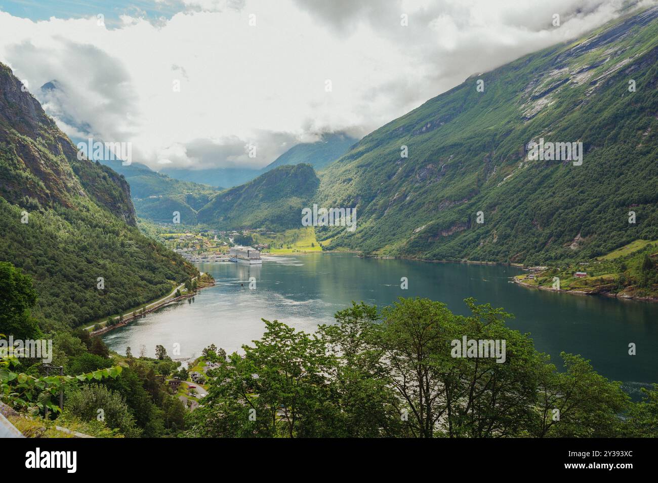 Bateau de croisière dans le fjord de Geiranger entouré de montagnes luxuriantes et escarpées Banque D'Images