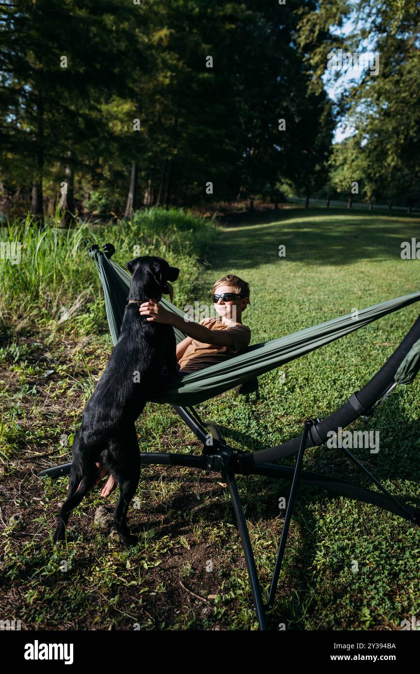 Personne se relaxant dans un hamac avec un chien heureux Banque D'Images