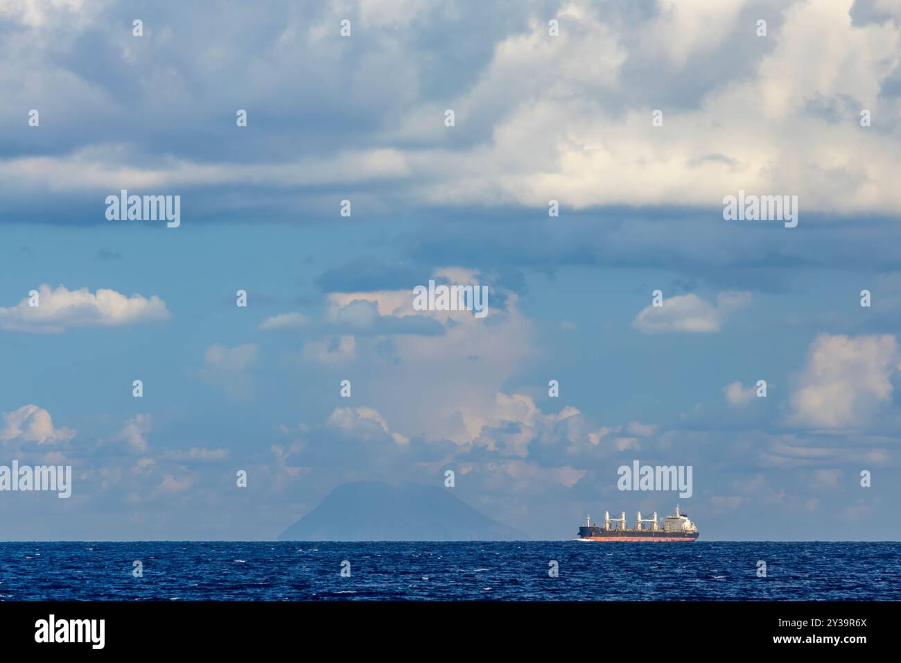 Cargo à proximité du phare de Capo Peloro à Punta del Faro sur le détroit de Messine, promontoire le plus nord-est de la Sicile, Italie Banque D'Images