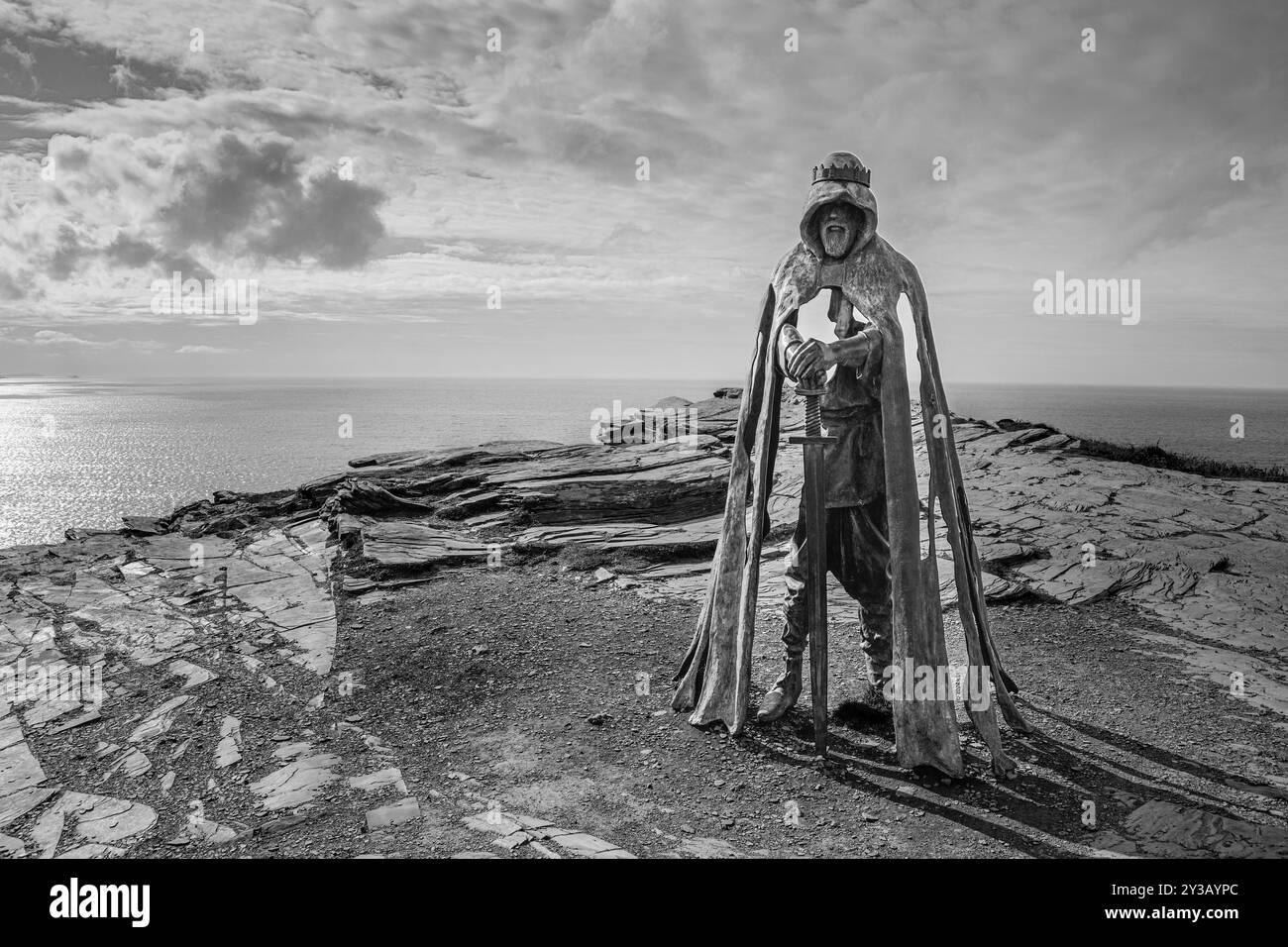 Image monochrome de la statue de bronze Gallos qui se dresse au sommet des falaises du château de Tintagel. Banque D'Images