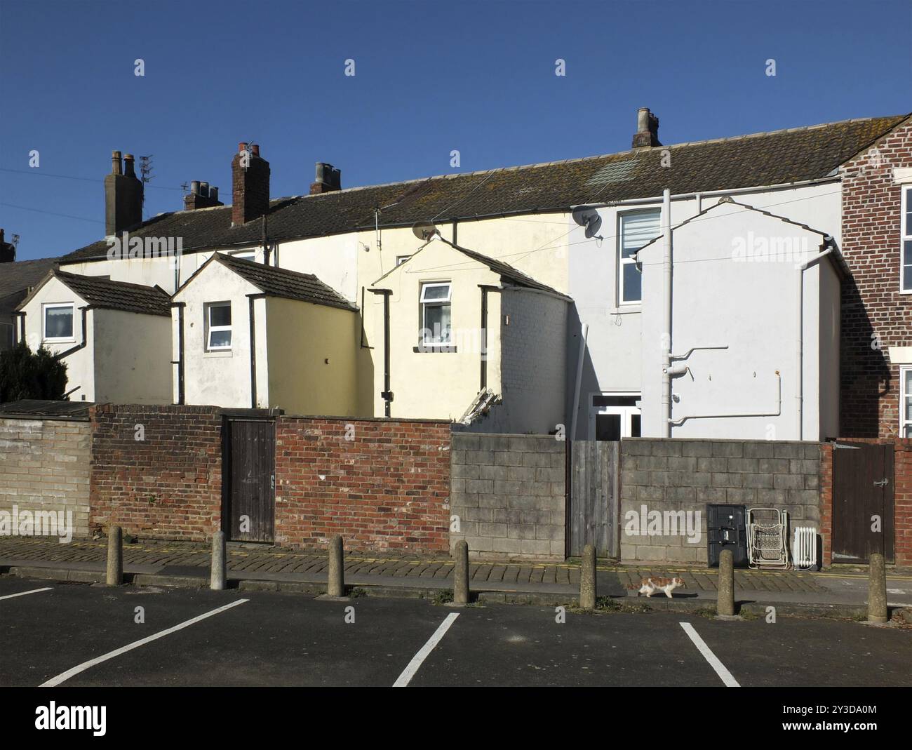 Vue de l'arrière d'une rangée de petites maisons mitoyennes anglaises peintes en blanc et jaune avec places de parking à fleetwood lancashire Banque D'Images