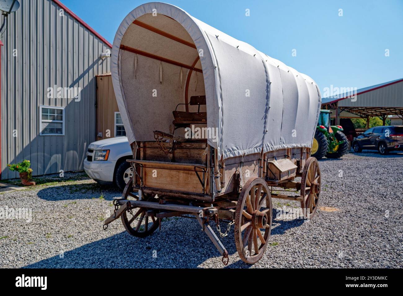 Un chariot à dos restauré authentique en bois avec une nouvelle bâche en toile enveloppant le wagon avant et vue latérale en gros plan garé dans une ferme par une journée ensoleillée en été Banque D'Images Un chariot à dos restauré authentique en bois avec une nouvelle bâche en toile enveloppant le wagon avant et vue latérale en gros plan garé dans une ferme par une journée ensoleillée en été Banque D'Images
