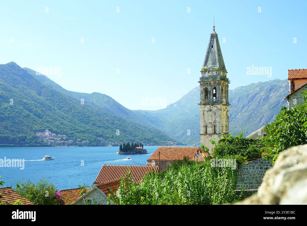 Paysage de Perast, Monténégro : clocher de l'église de équipés Nicholas, toits de tuiles et la mer avec des bateaux naviguant vers l'île de équipés George Banque D'Images