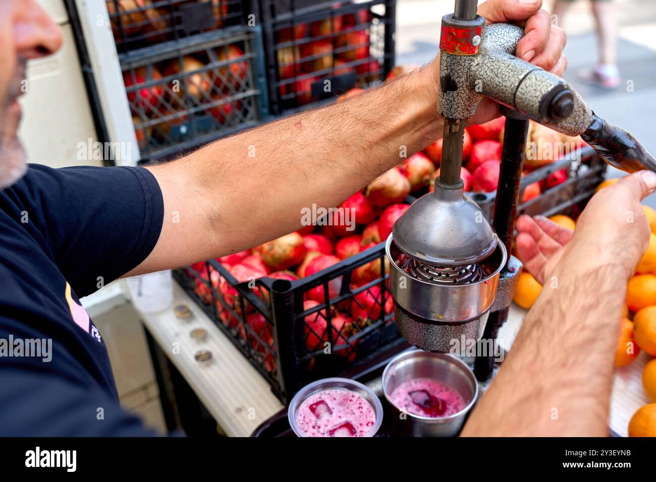 Kusadasi, Turquie - 1er septembre 2024 : à Kusadasi, le jus de grenade frais est pressé directement dans la rue. Le vendeur de rue propose une boisson rafraîchissante et saine à base de fruits régionaux *** à Kusadasi wird frischer Granatapfelsaft direkt auf der Straße gepresst. Der Straßenverkauf bietet eine erfrischende und gesunde Erfrischung aus regionalen Früchten Banque D'Images