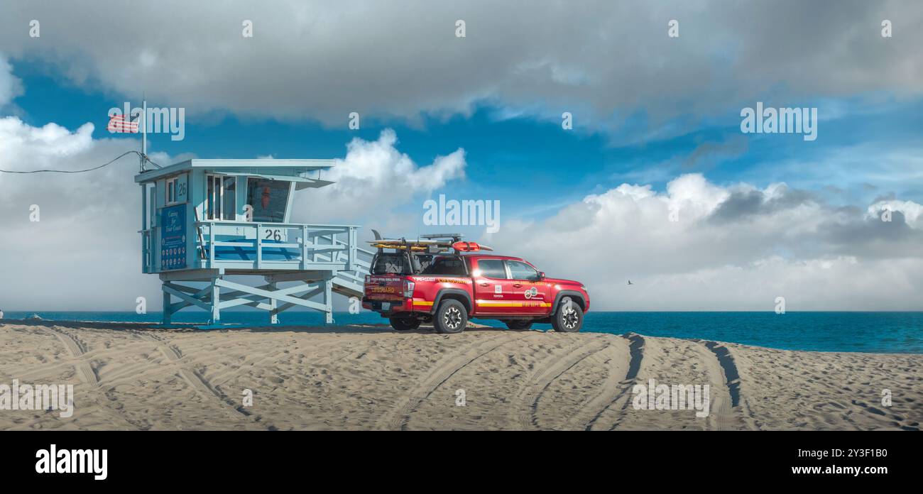 Panorama de la plage de Santa Monica avec tour de sauveteur et camion de sauveteur rouge sous un beau ciel bleu avec des nuages pittoresques. Los Angeles, Californie. Banque D'Images
