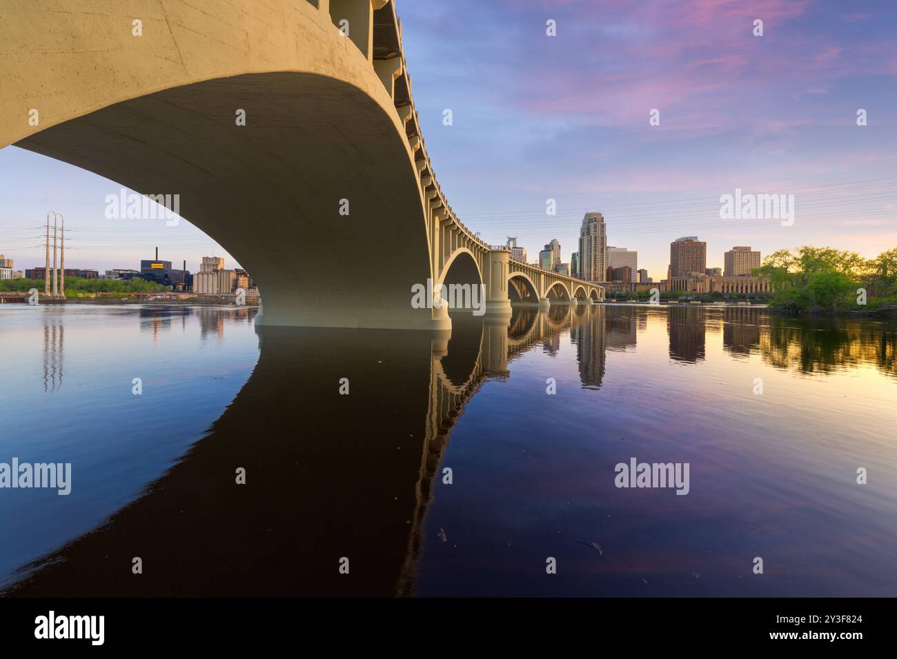 Minneapolis, Minnesota, USA ligne d'horizon du centre-ville sur le fleuve Mississippi avec le pont de la troisième Avenue au crépuscule. Banque D'Images