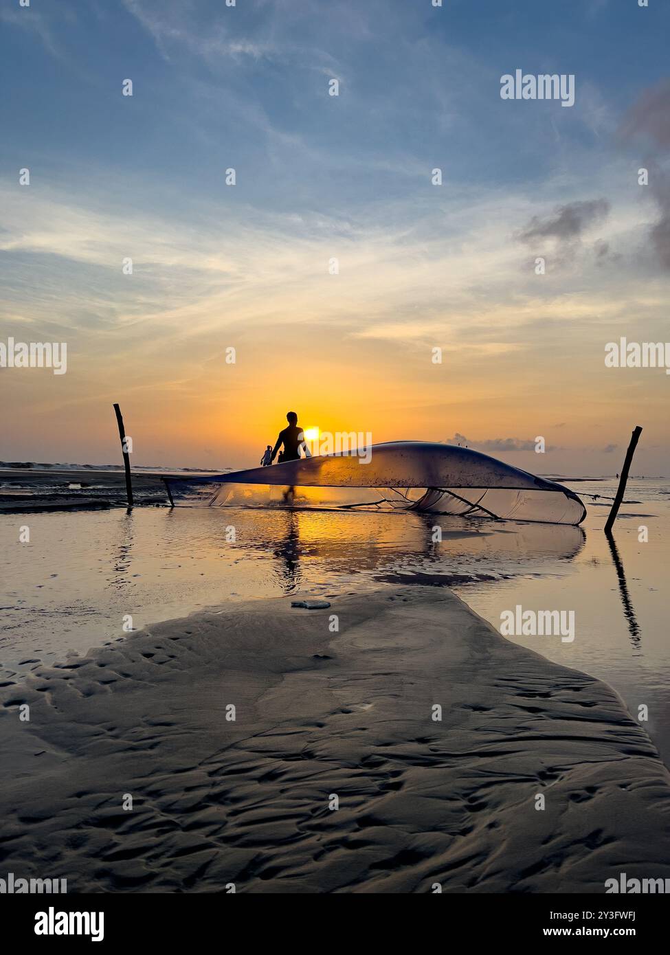 Industrie de la pêche au Bangladesh. Pêcheur avec filet à Cox's Bazar Beach pendant le coucher du soleil. Concept d'économie du Bangladesh Banque D'Images