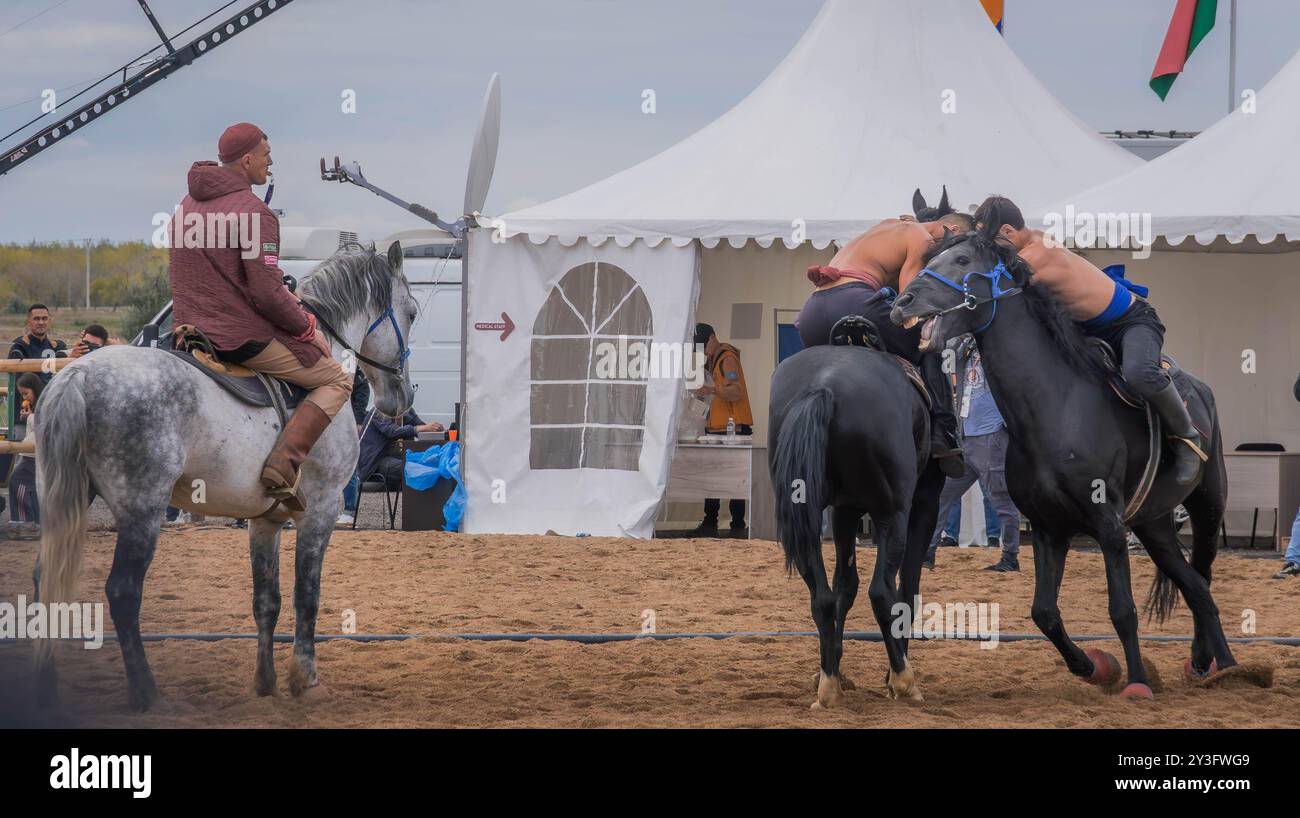 Les athlètes montés luttent dans la compétition Audaryspak, un combat de cavalier traditionnel, pendant les Jeux mondiaux du nomade à Astana, au Kazakhstan. Banque D'Images