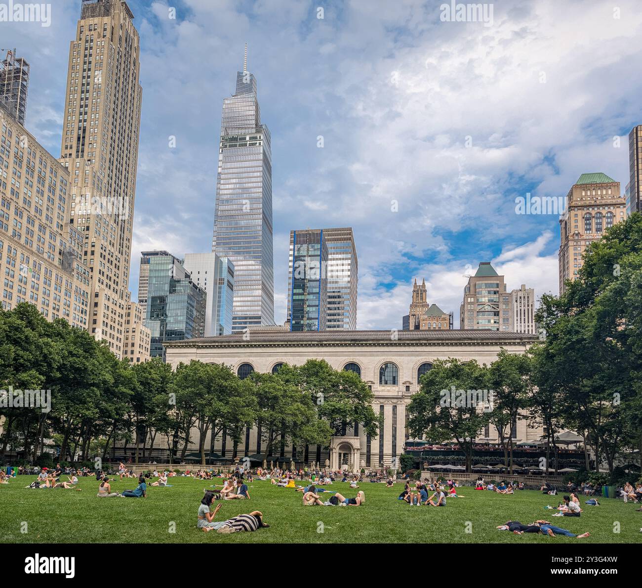 Vue des gens se relaxant dans Bryant Park à New York sur une belle journée d'été ; gratte-ciel et ciel en arrière-plan Banque D'Images