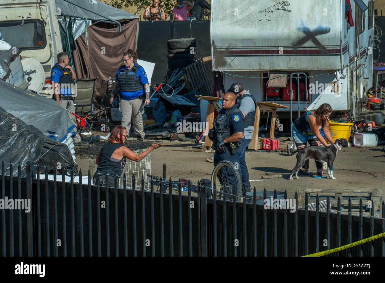 Sacramento, CA. 26 août 2024. Chastty May, 50, à gauche, tente de sauver sa remorque, ses effets personnels et trois chiens alors que la police de Sacramento et les équipages de la ville démantelent Camp Resolution le lundi 26 août 2024. « J'ai dû me battre avec eux pour obtenir un autre sac de vêtements », a déclaré May, qui vivait dans le camp des sans-abri depuis deux ans. 'D'abord, (application du code) m'a dit qu'ils allaient étiqueter ma remorque) et nous avons eu un peu de temps pour la sortir. Puis la police est entrée et m'a dit qu'ils outrepassaient l'application du code et qu'ils allaient détruire la remorque maintenant et que je ferais mieux d'avoir ce que je peux et de me dépêcher Banque D'Images