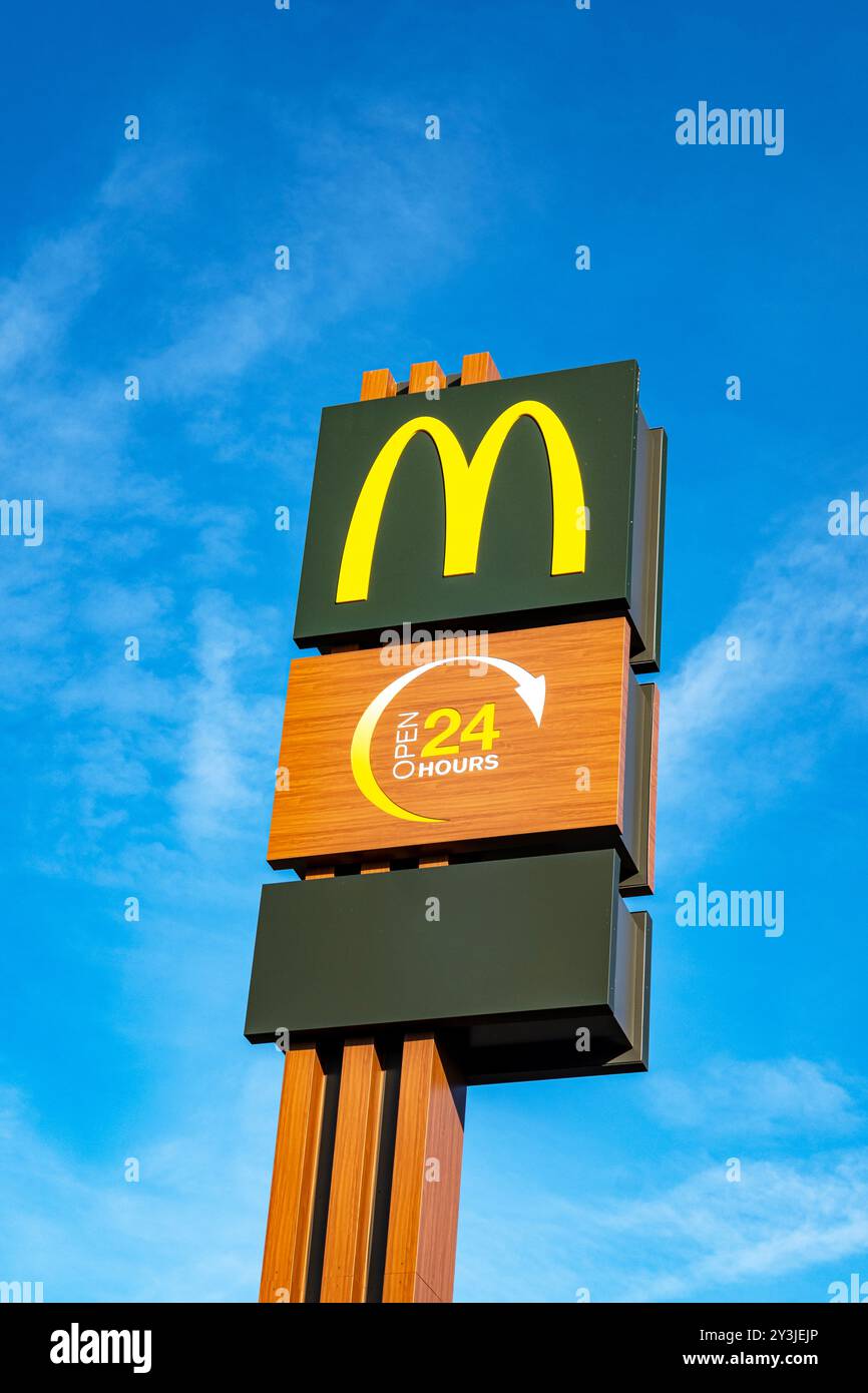 Panneau McDonald's ouvert 24 heures isolé contre le ciel bleu Banque D'Images