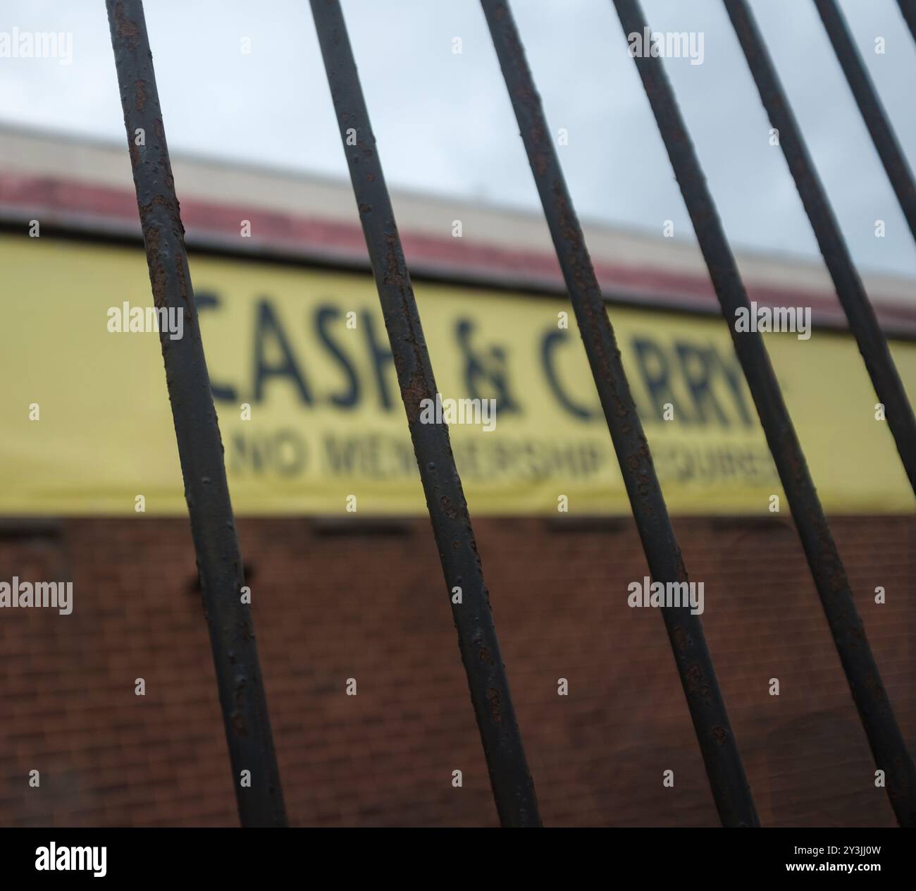 Un panneau pour Un Cash & Carry (vente en gros) derrière des garde-corps métalliques Banque D'Images