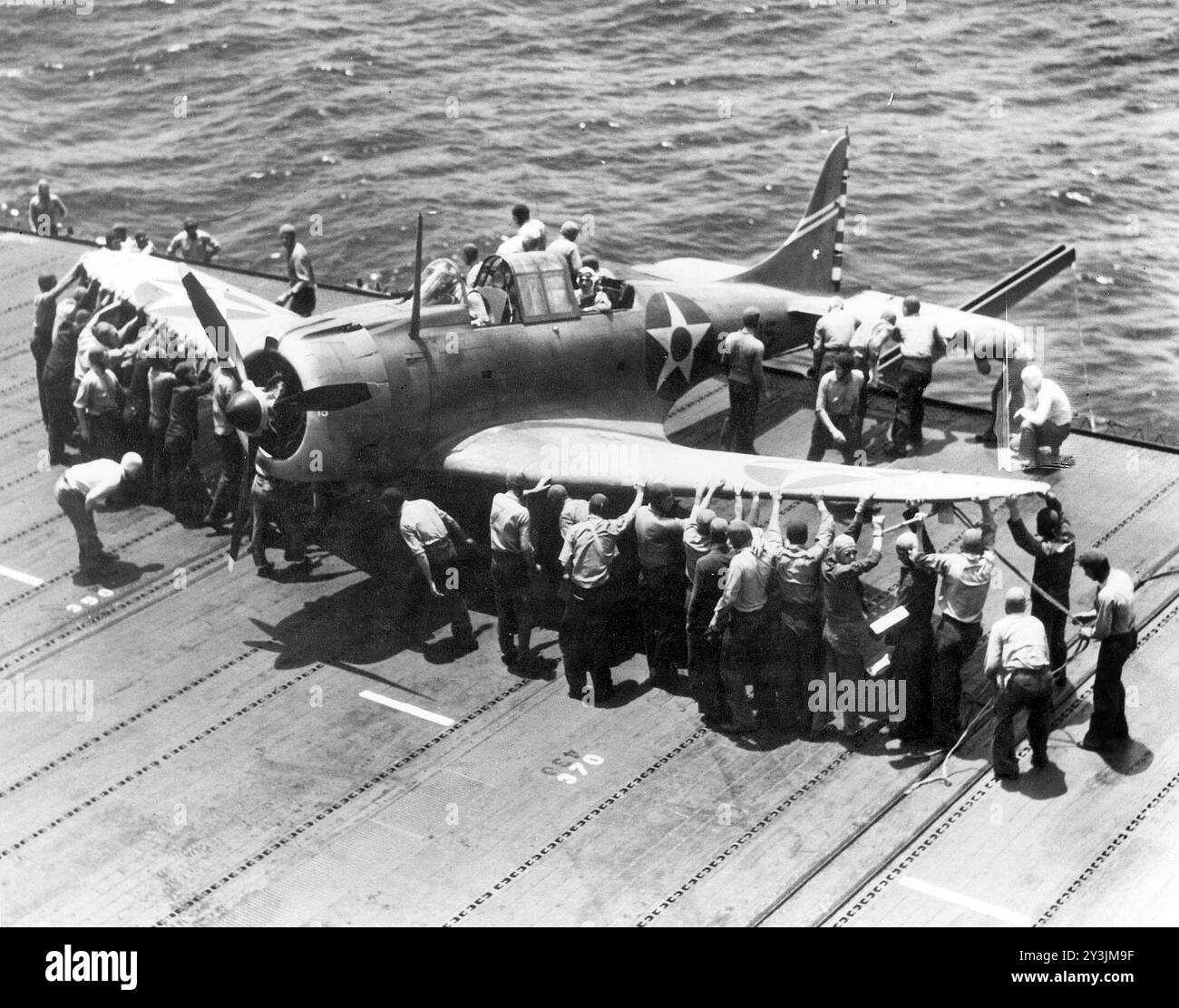 Le personnel du pont d'envol de l'US Navy manœuvre un Douglas SBD-3 Dauntless de l'escadron de bombardement VB-6 sur une roue de bord de pont sur le porte-avions USS Enterprise (CV-6), 17 avril 1942 - photo de l'US Navy Banque D'Images