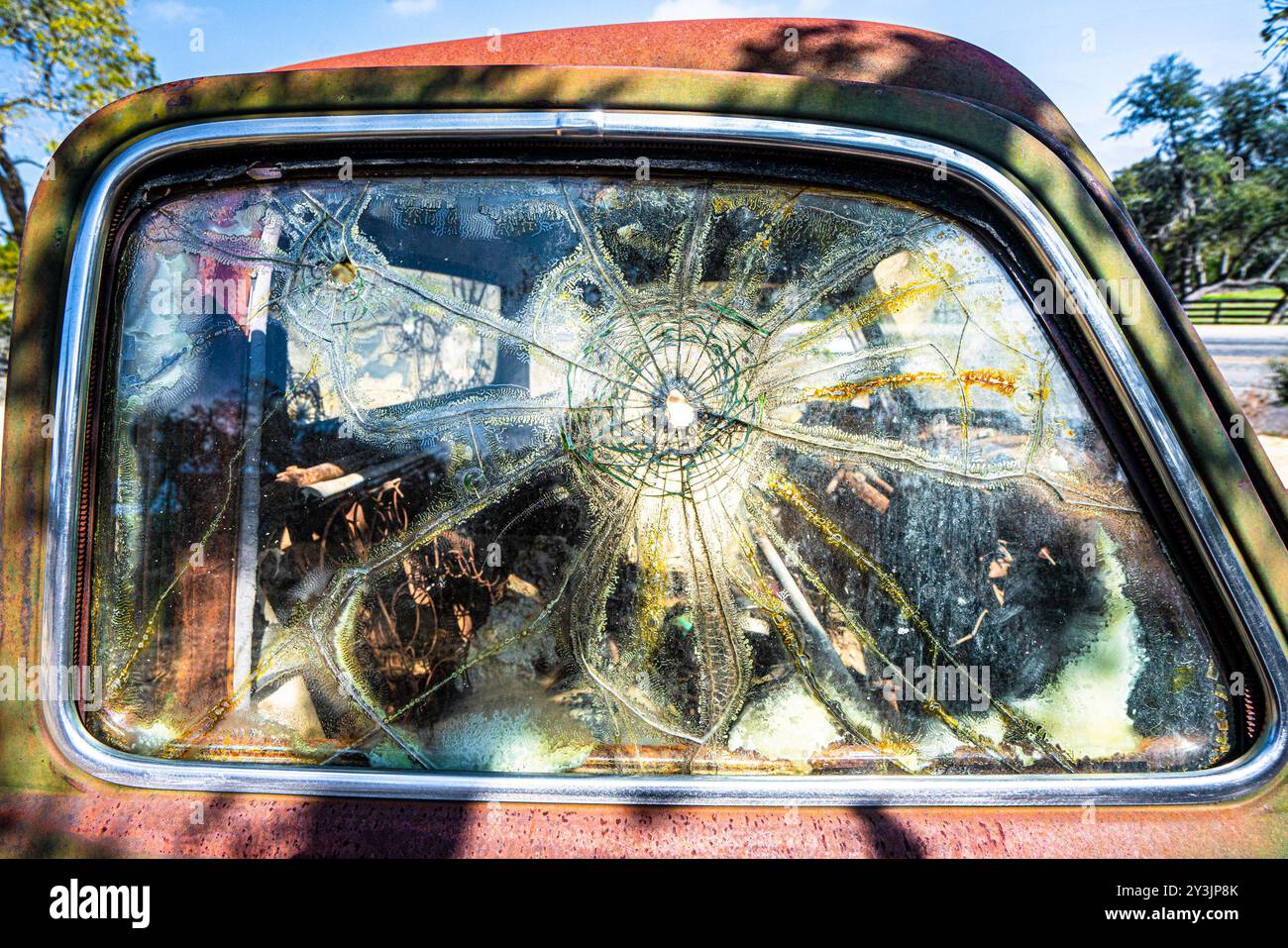 Fenêtre fissurée sur une vieille voiture ancienne junkyard Banque D'Images