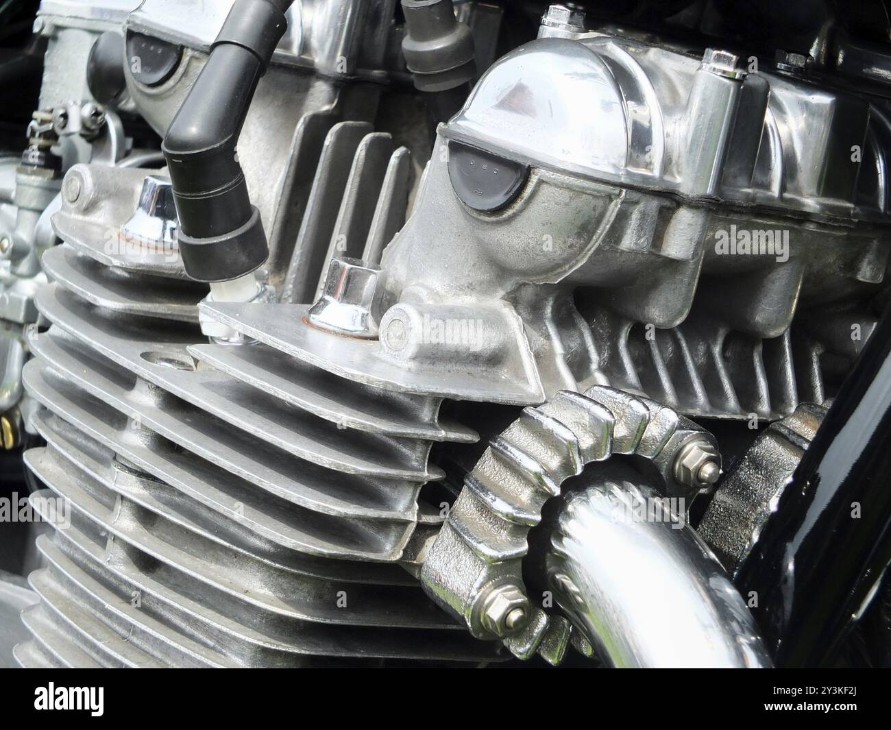 Gros plan sur le moteur d'une vieille moto vintage avec cadre noir et tuyaux d'échappement chromés brillants Banque D'Images