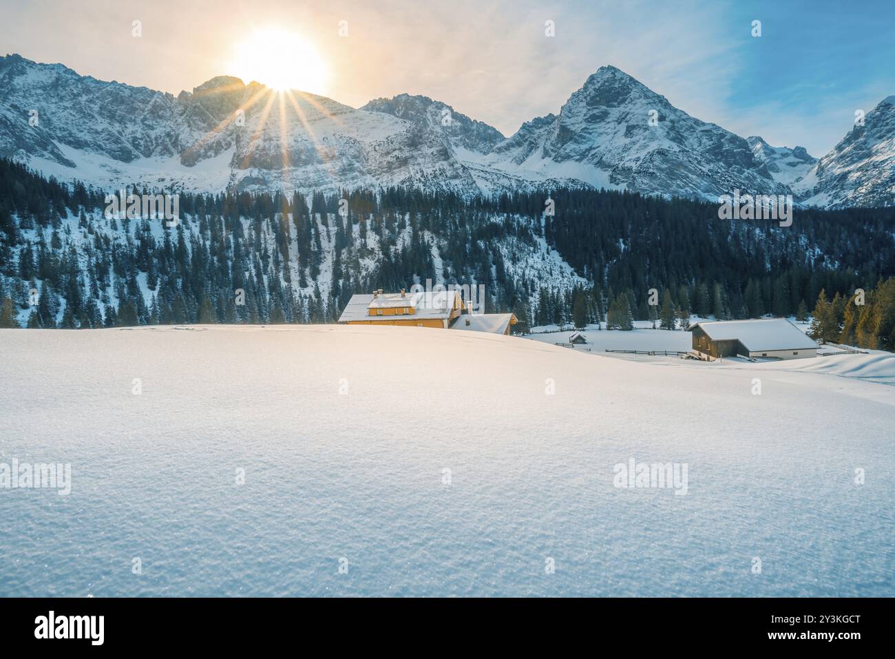 Paysage hivernal idyllique avec des tas de neige, les montagnes des Alpes autrichiennes et des maisons rustiques, réchauffées par les rayons du soleil de décembre. Image prise à Ehrwald Banque D'Images