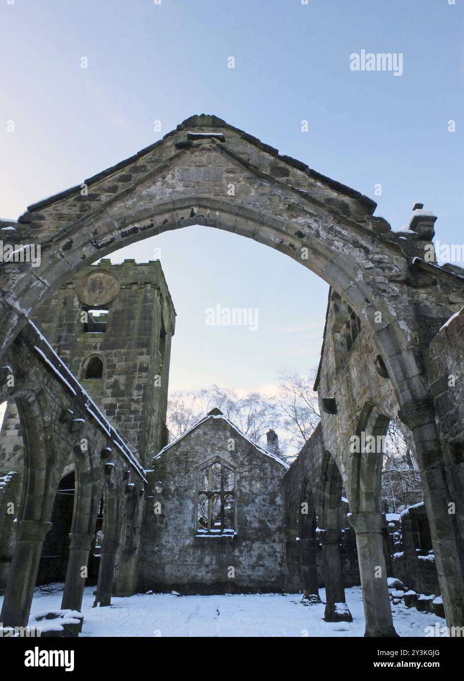 L'église médiévale en ruine en heptonstall couverte de neige montrant des arches et des colonnes contre un ciel bleu d'hiver Banque D'Images