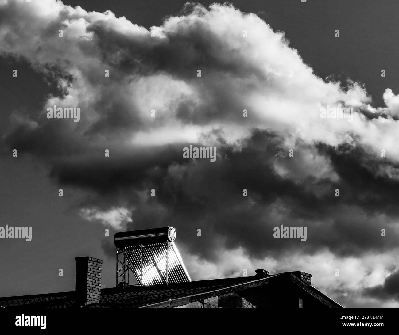 Panneau solaire absorbant l'énergie solaire pendant le coucher du soleil avec formation spectaculaire de nuages. Banque D'Images