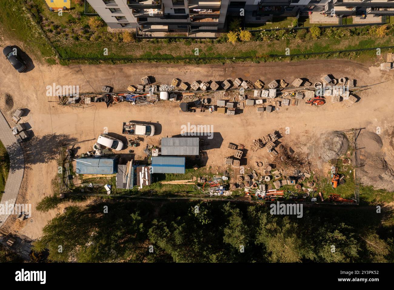 Vue aérienne d'un chantier de construction présentant divers matériaux et équipements de construction. Le site comprend des piles de briques, des blocs de béton. Sur Banque D'Images