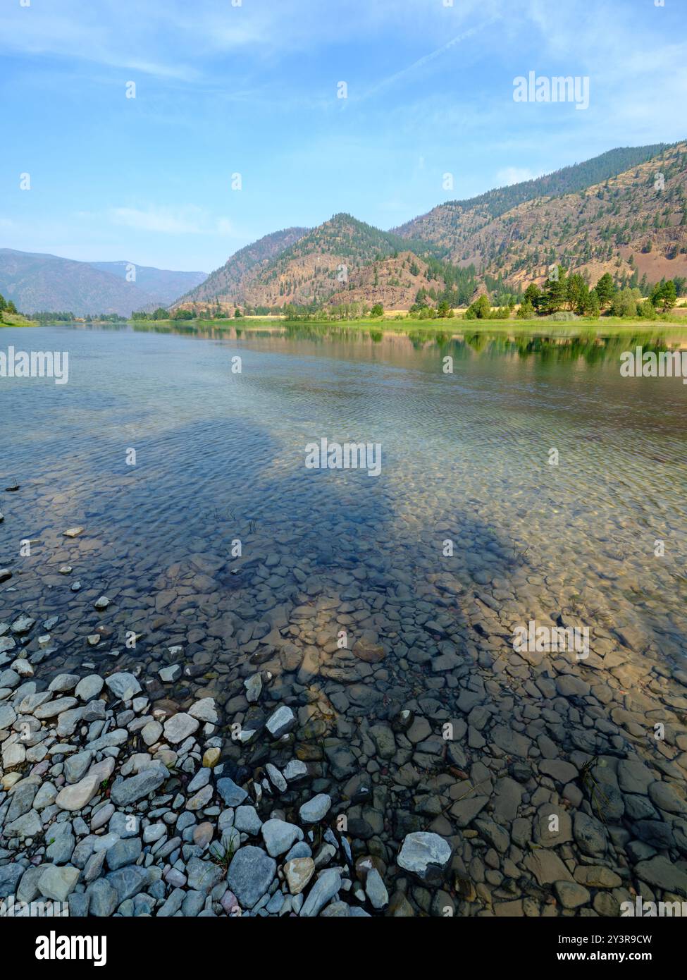 Les montagnes s'élèvent au-dessus des rives de la rivière Flathead près de Knowles dans le Montana, aux États-Unis Banque D'Images