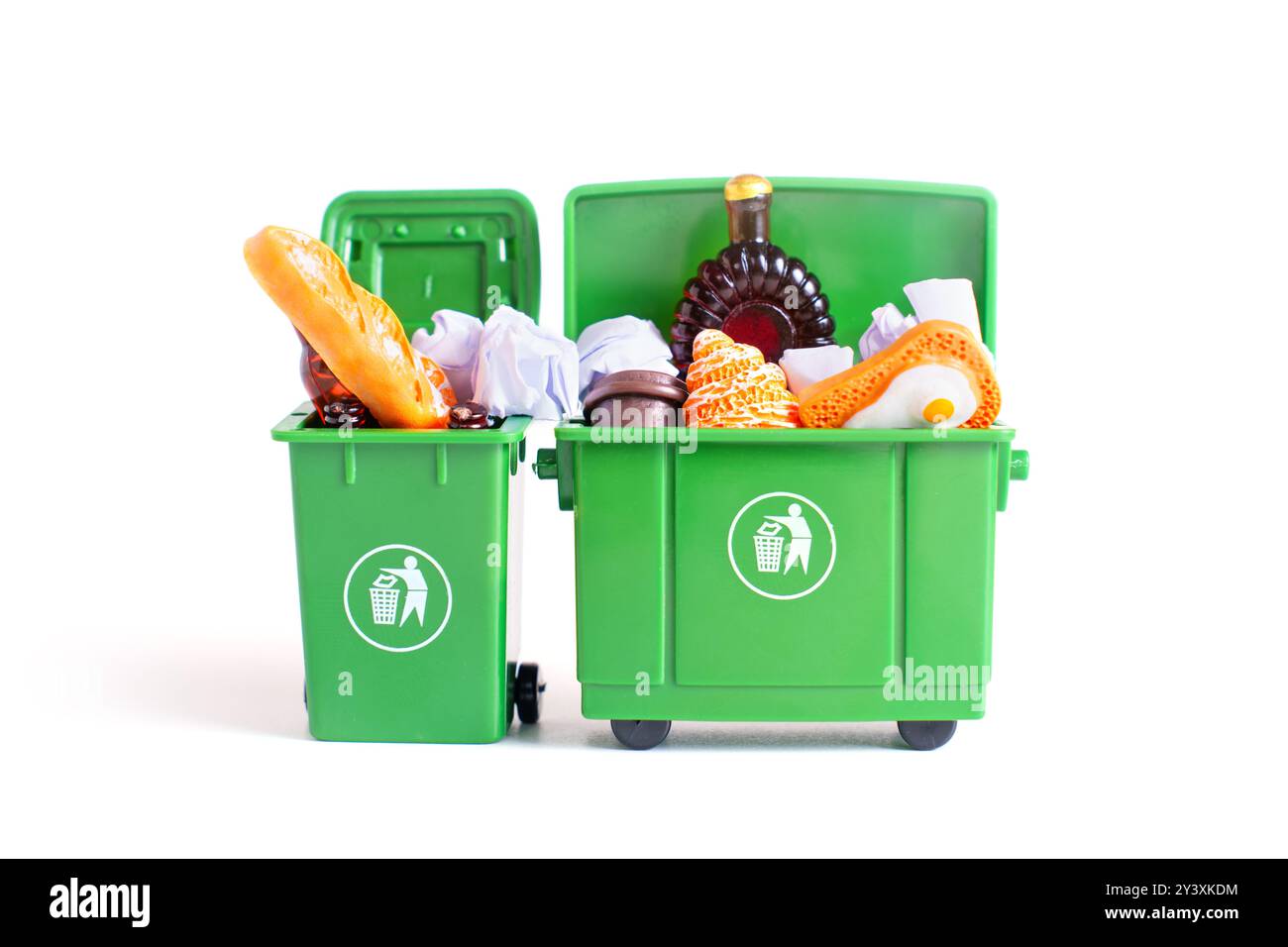 Deux poubelles miniatures vertes remplies de divers déchets, présentant des concepts de gestion et de tri des déchets. Banque D'Images