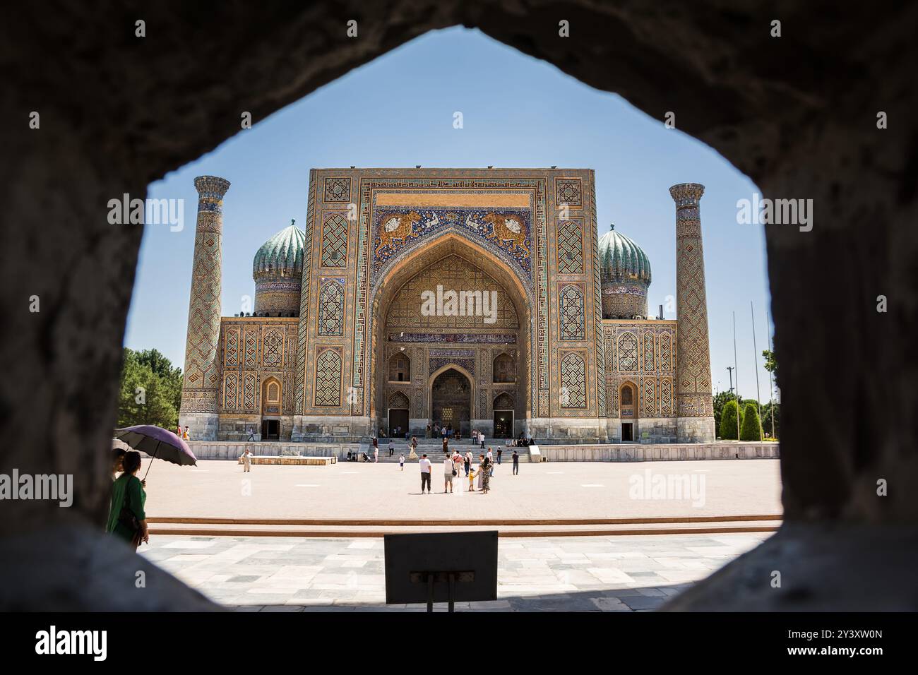 Samarcande, Ouzbékistan - 05 juillet 2024 : façade de la Madrasah Sher-Dor avec des touristes dans le Registan de Samarcande Banque D'Images