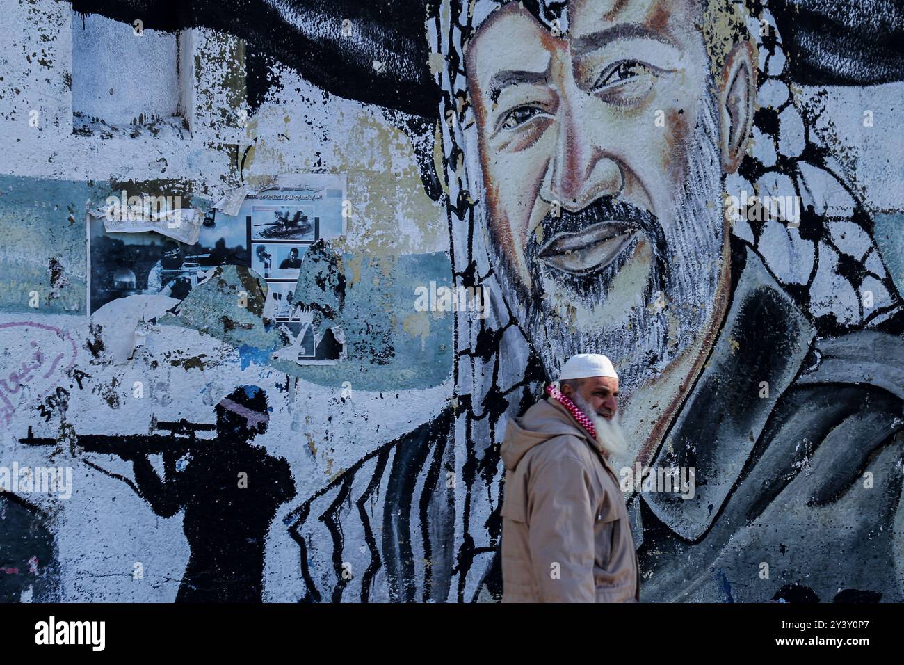 Gaza, Palestine. 29 décembre 2019. Un palestinien passe devant une fresque murale du fondateur et président du Fatah, Yasser Arafat, lors d’un défilé militaire organisé par des membres des divisions d’infanterie et de cavalerie du bataillon Al-Amoudi du Fatah dans la ville de Gaza. Les membres du bataillon Nidal Al-Amoudi des martyrs d'Al-Aqsa ont défilé à Gaza pour marquer le 55 e anniversaire de la fondation du mouvement palestinien du Fatah Banque D'Images