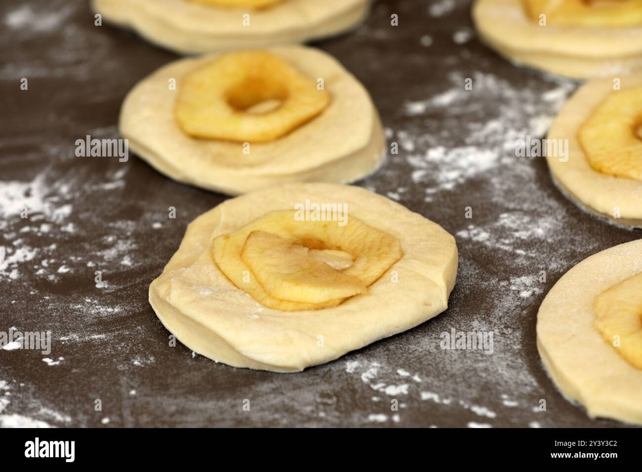 La pomme sonne sur une planche avant la cuisson Banque D'Images